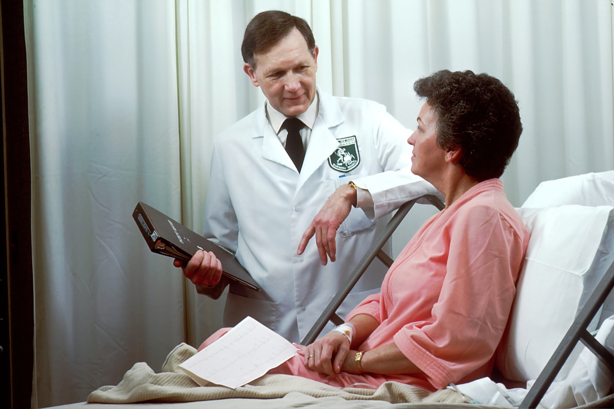 A clinician reviewing a chart in conversation with a patient